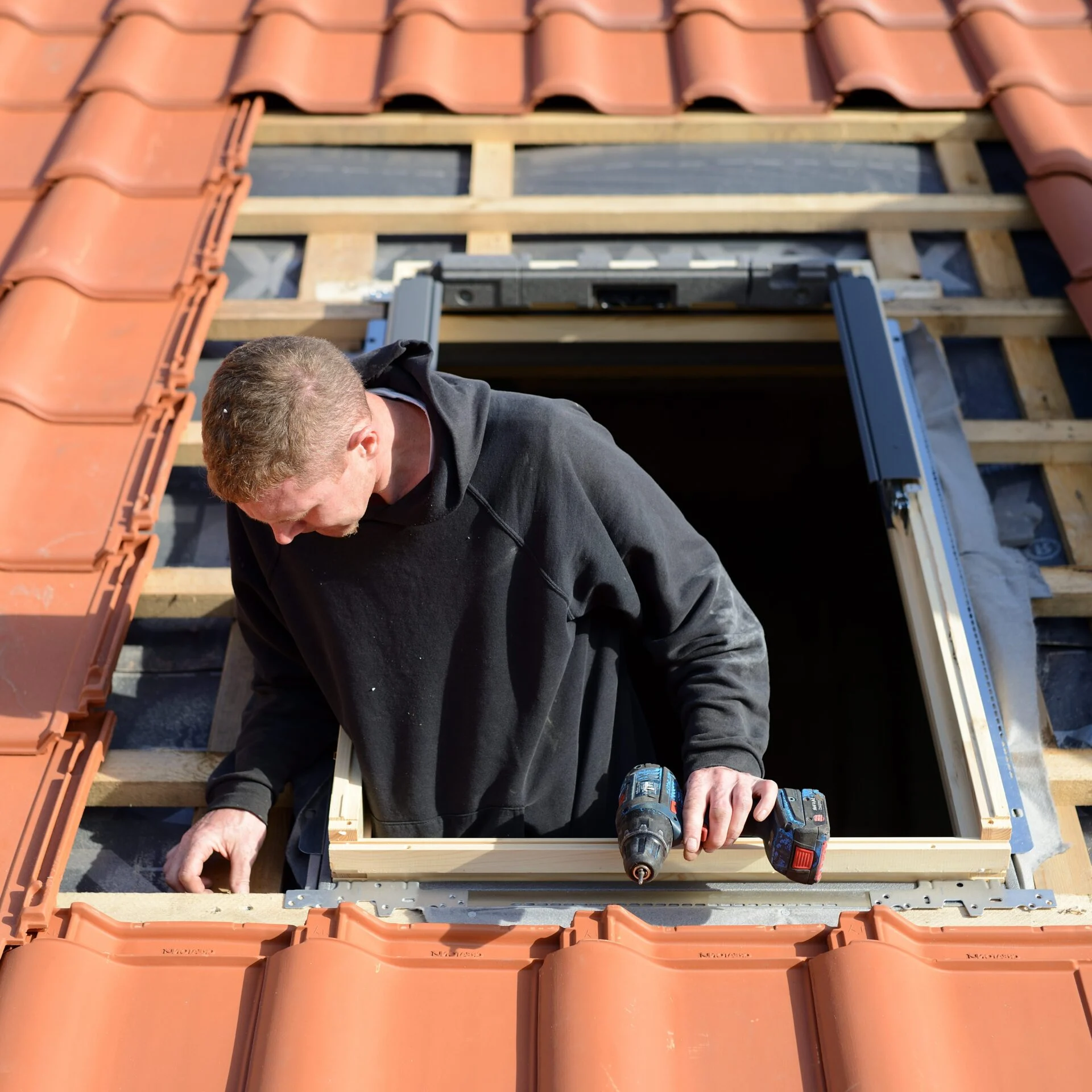 Software für Dachfensterbauer Dachfensterbauer montiert ein Dachfenster auf einem Ziegeldach